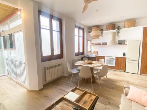 eine Küche und ein Wohnzimmer mit einem Tisch und Stühlen in der Unterkunft Apartamento mediterraneo, nuevo y acogedor de Eva in Sant Feliu de Guixols