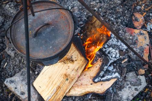 eine Kanne auf einem Holzbrett mit Feuer in der Unterkunft Jammerbugt Glamping in Brovst
