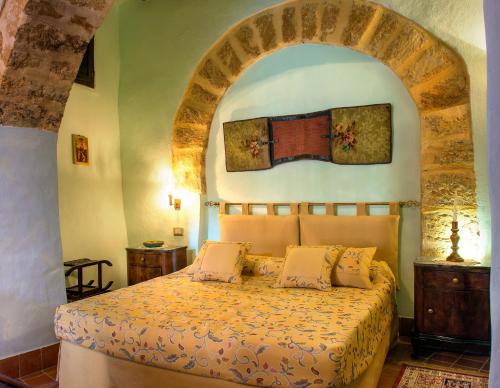 1 dormitorio con 1 cama con arco encima en Meliaresort Dimore Storiche, en Mazara del Vallo