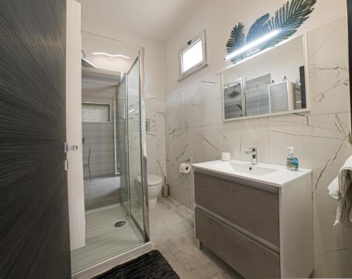 La salle de bains est pourvue d'une douche, d'un lavabo et de toilettes. dans l'établissement Deep Sea Residence, à Agrigente