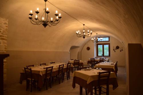 a dining room with tables and chairs and a chandelier at Il pozzo dei desideri in Castelnuovo