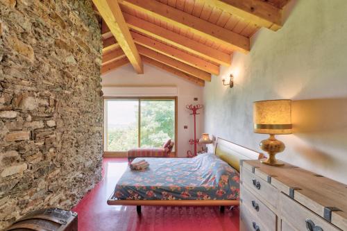 1 dormitorio con cama y pared de piedra en chalet con piscina e vista panoramica en Colico