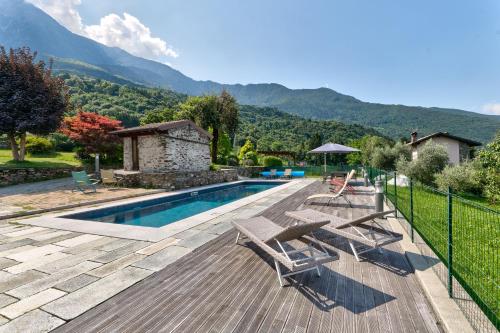 a swimming pool with two chairs and a house at chalet con piscina e vista panoramica in Colico