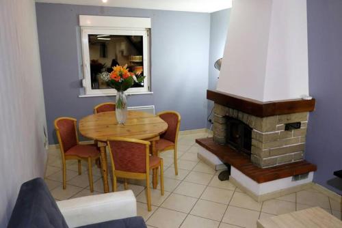 une salle à manger avec une table et une cheminée dans l'établissement Maison Rurale En Bordure De Forêt, à Schirmeck