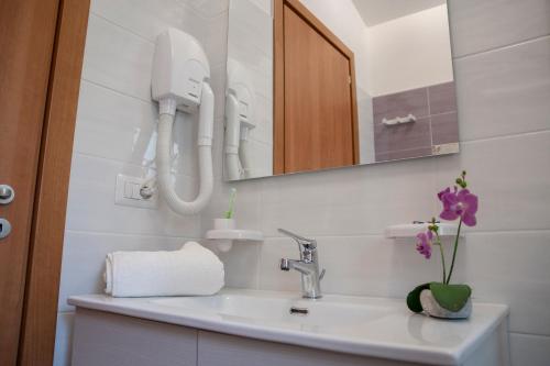 a white bathroom with a sink and a mirror at Il Mirto Residence in Marina di Camerota