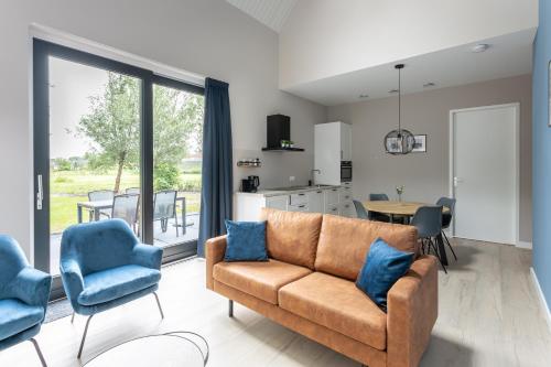 een woonkamer met een bank en blauwe stoelen bij Chezeehoeve - Wemeldinge in Wemeldinge