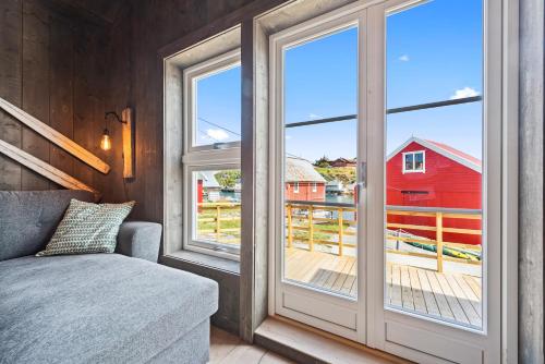 a room with a sliding glass door with a view of a red barn at Kronborg marina in Averoy
