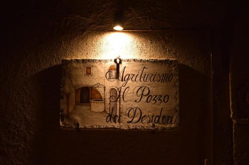 a sign on the side of a building with a light at Il pozzo dei desideri in Castelnuovo