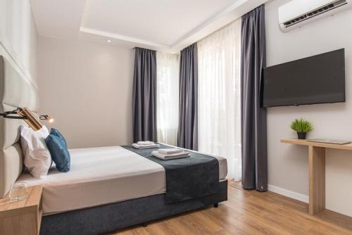 a bedroom with a bed and a flat screen tv at Casa Paradiso Apartments in Ahtopol