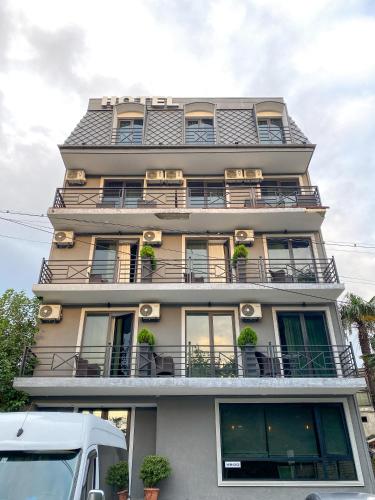 a tall building with balconies and potted plants on it at Ponte in Kutaisi