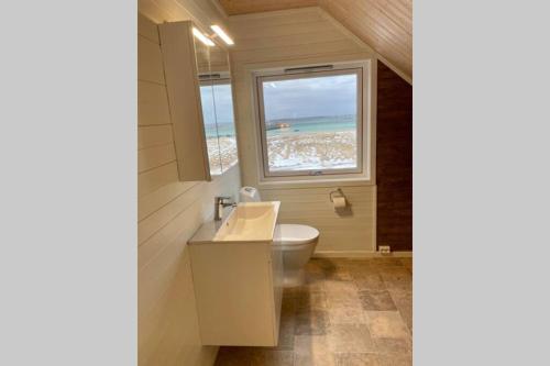 a bathroom with a sink and a window with a beach at Lofoten_Beach_Eggum in Eggum
