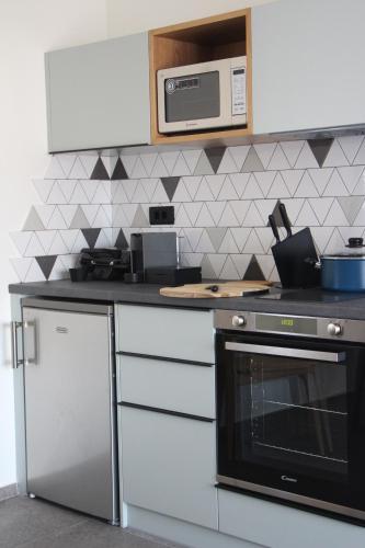 a kitchen with a stove and a microwave at Chill and Thrill Apartments in Mastichari