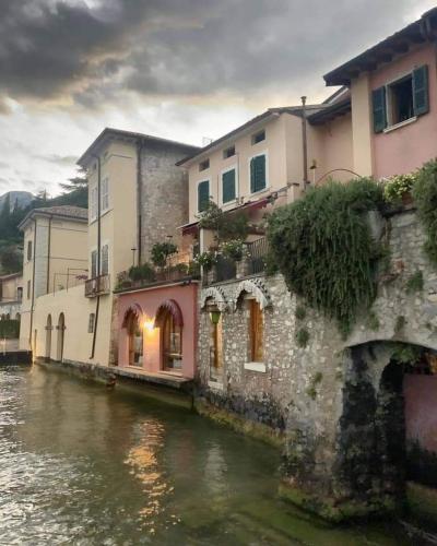 a group of buildings sitting next to a river at Hotel Garnì Bartabel in Gargnano