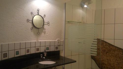 a bathroom with a sink and a mirror on the wall at Studio Formana in Florianópolis