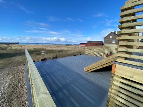 a deck on the beach with a house in the background at Lofoten_Beach_Eggum in Eggum