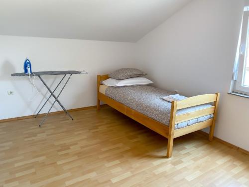 a small bedroom with a bed and a desk at Maslina Apartments in Široki Brijeg