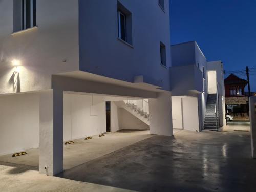 Tefkrou Anthia 9 apts في أيا نابا: مبنى أبيض كبير به درج في مقدمته