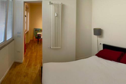 una camera con un letto bianco e un cuscino rosso di Potenza Studio - in Centro Città a Potenza