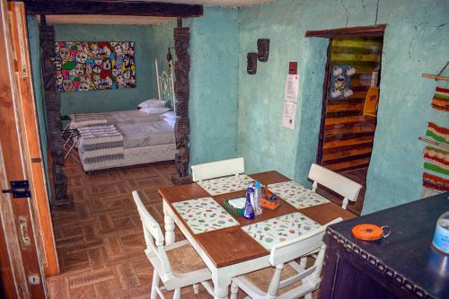 a dining room with a table and chairs and a bedroom at Cabañas El Desván in Puente Negro