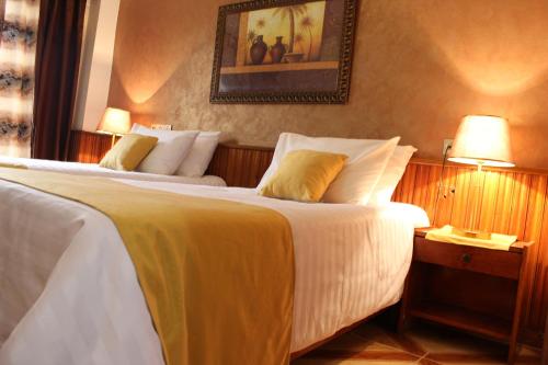 pokój hotelowy z 2 łóżkami i zdjęciem na ścianie w obiekcie Hotel el Hayat w Batinie