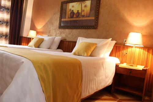 a hotel room with two beds and a picture on the wall at Hotel el Hayat in Batna