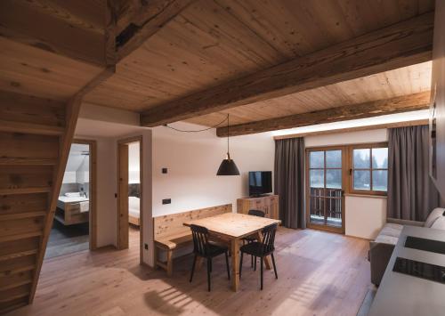 a dining room and living room with a table and chairs at Unterweckerlerhof in Valle Di Casies