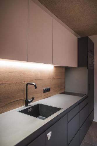 a kitchen with white cabinets and a sink at Unterweckerlerhof in Valle Di Casies