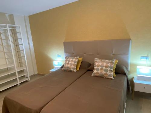 Un dormitorio con una cama grande con dos almohadas encima. en Manila Playa, en Almuñécar