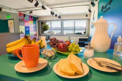 a table with plates of bread and fruit on it at Hostel Hormiga Negra in San Carlos de Bariloche