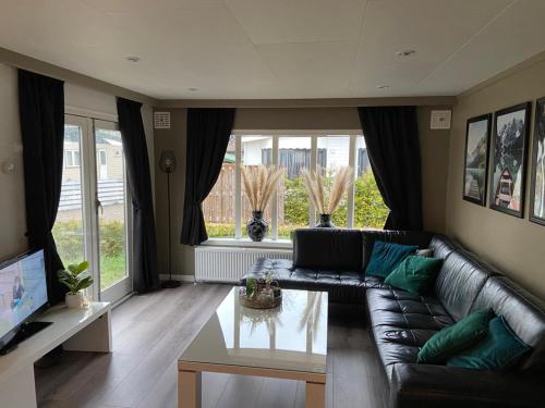 a living room with a leather couch and a coffee table at Luxe Chalet 146 in Putten