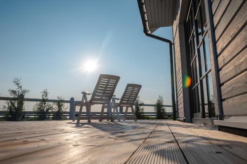two chairs sitting on a deck with the sun in the background at Pakri Parun in Paldiski