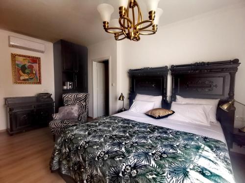 a bedroom with a large bed and a chandelier at L&L Rooms Royal in Šibenik