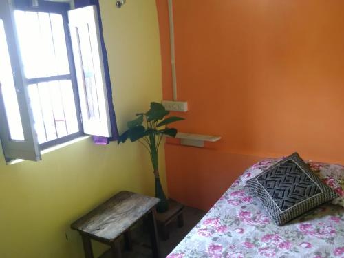 a bedroom with a bed and a table and a window at Shiva lodge in Varanasi