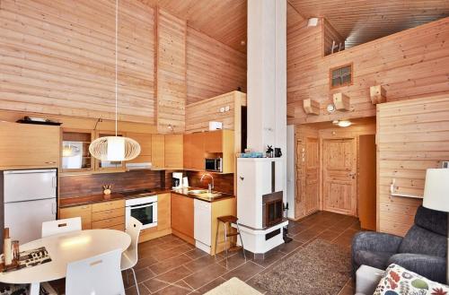 cocina con paredes de madera, mesa y nevera en Ylläs Eeli, en Ylläs