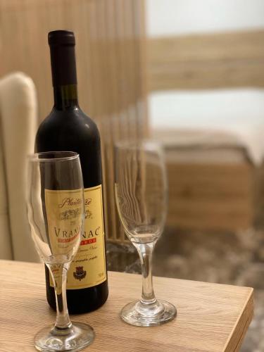 a bottle of wine and two wine glasses on a table at VILLA MILENA in Kotor