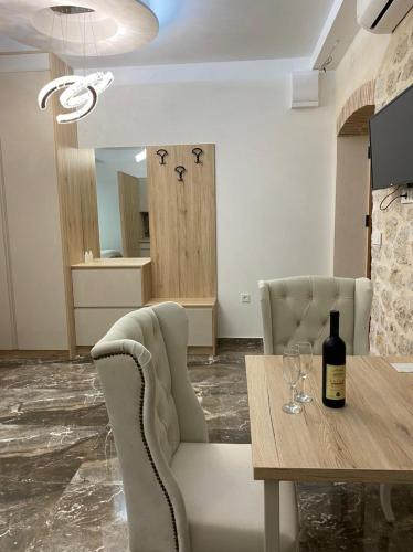 a dining room with a table and a bottle of wine at VILLA MILENA in Kotor
