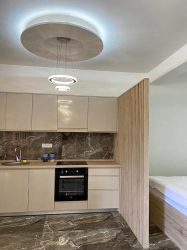 a kitchen with white cabinets and a large light fixture at VILLA MILENA in Kotor