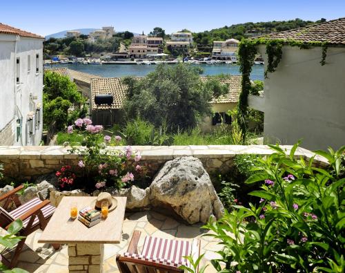 a patio with a table and chairs and a rock at Villa Edem in Kassiopi