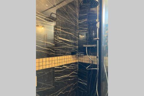 La salle de bains est pourvue d'une douche en marbre noir. dans l'établissement Studio COSY et confortable aux PORTES DE PARIS!, à Saint-Denis