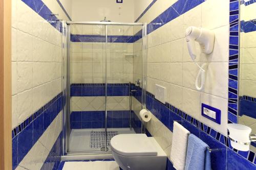 a blue and white bathroom with a shower and a toilet at Le Perle d'Italia in Ravello