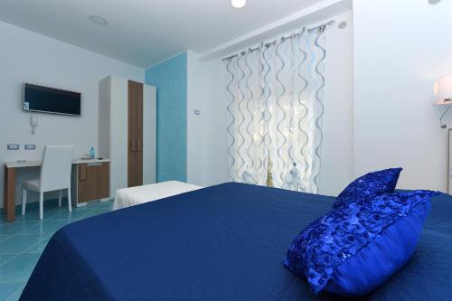 a bedroom with a blue bed with a blue pillow at Le Perle d'Italia in Ravello