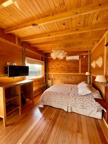 a bedroom in a log cabin with a bed and a desk at Eco Cabaña Río con Pileta privada in Tigre