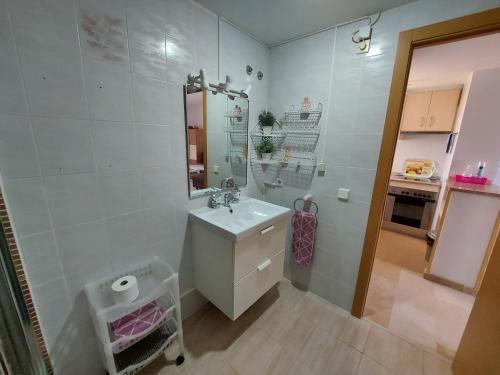 a white bathroom with a sink and a mirror at Apartment Diamond in Benidorm