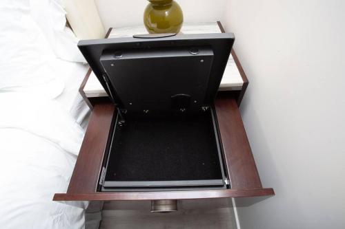 a bedside table with a vase on top of it at Comfy Studio with Cali King Size Mattress in San Diego