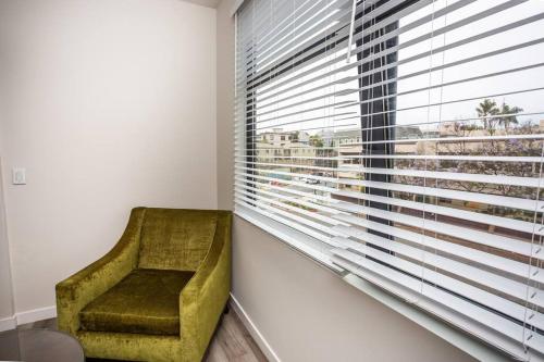 a green chair sitting in front of a window at Comfy Studio with Cali King Size Mattress in San Diego