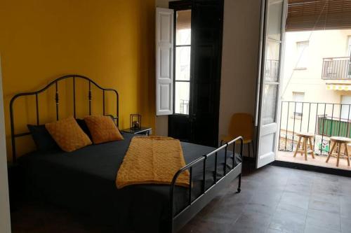 a bedroom with a black bed and a balcony at Reus, amazing apartment in the city centre. in Reus