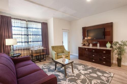 a living room with a purple couch and a tv at 1-Bedroom with Cali King Size Bed in San Diego in San Diego