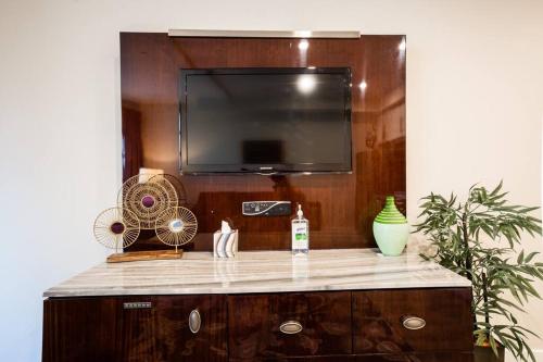 a entertainment center with a flat screen tv and a fan at 1-Bedroom with Cali King Size Bed in San Diego in San Diego