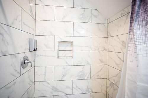 a bathroom with a shower with white marble tiles at 1-Bedroom with Cali King Size Bed in San Diego in San Diego