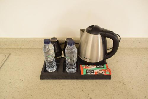 a tea kettle and two water bottles on a tray at منام الخزامى للشقق المخدومة in As Sulaymānīyah